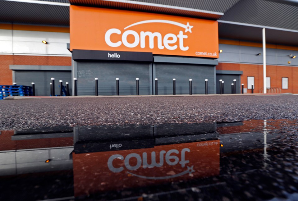 Reflection of a closed Comet electronics store in a puddle.