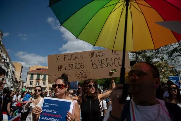 (FILES) Protesters take part in a demonstration to protest against the mass tourism and housing prices in Malaga on June 29, 2024. Spain's leftist government on May 19, 2025 said it had ordered tourist rental platform Airbnb to take down more than 65,000 illegal adverts as it tries to balance the flourishing sector against a housing crisis. (Photo by JORGE GUERRERO / AFP) (Photo by JORGE GUERRERO/AFP via Getty Images)