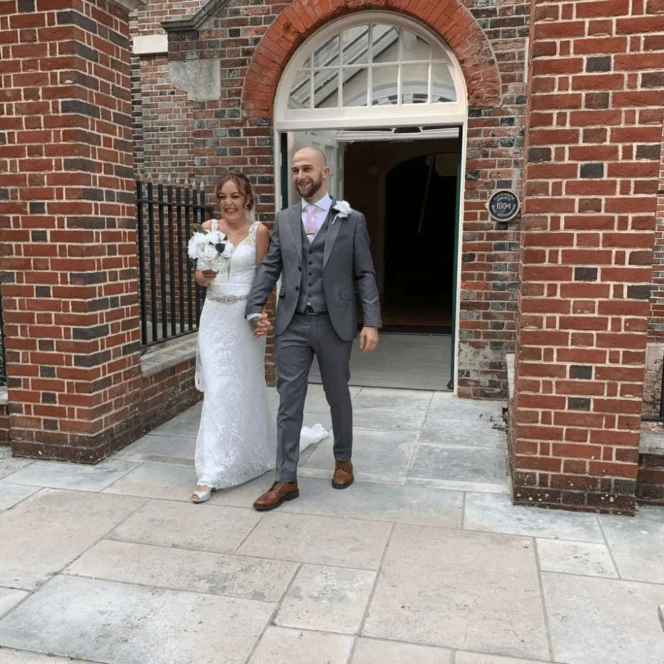 Newlywed couple leaving a building.