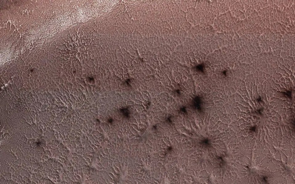 Mars surface with dark spots.