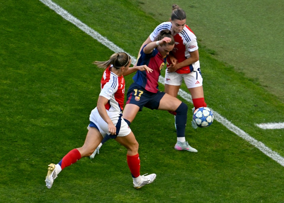 Three women soccer players vying for the ball.