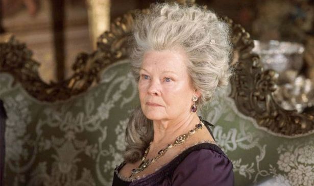 A woman with white hair sits on a chair