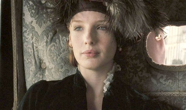 A woman in a black hat looks serious