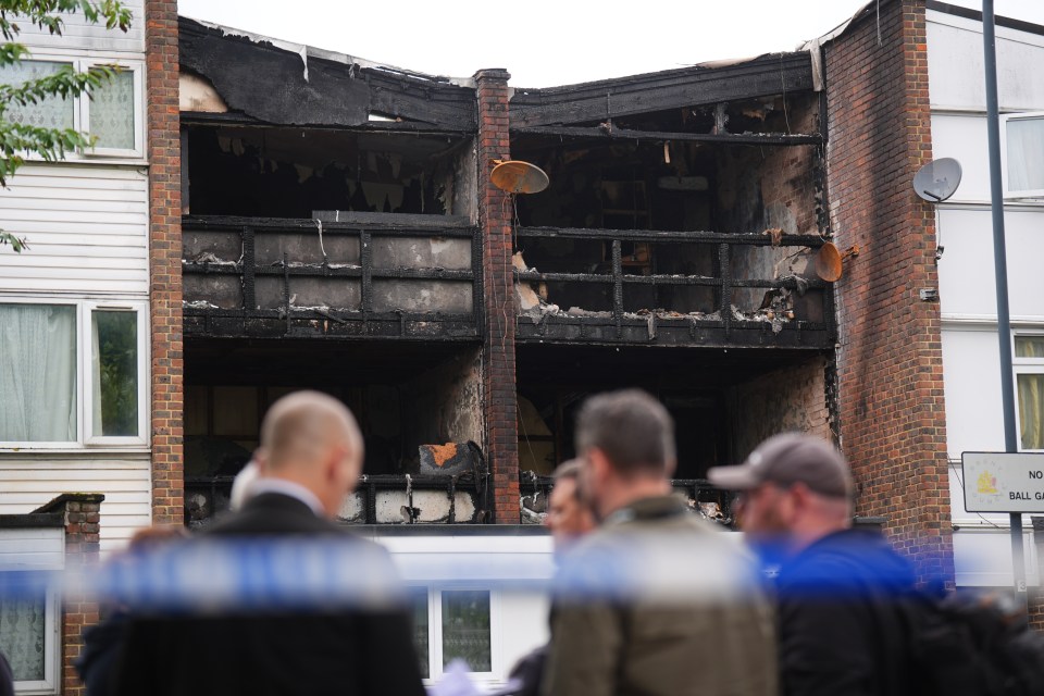 Fire-damaged building with onlookers.