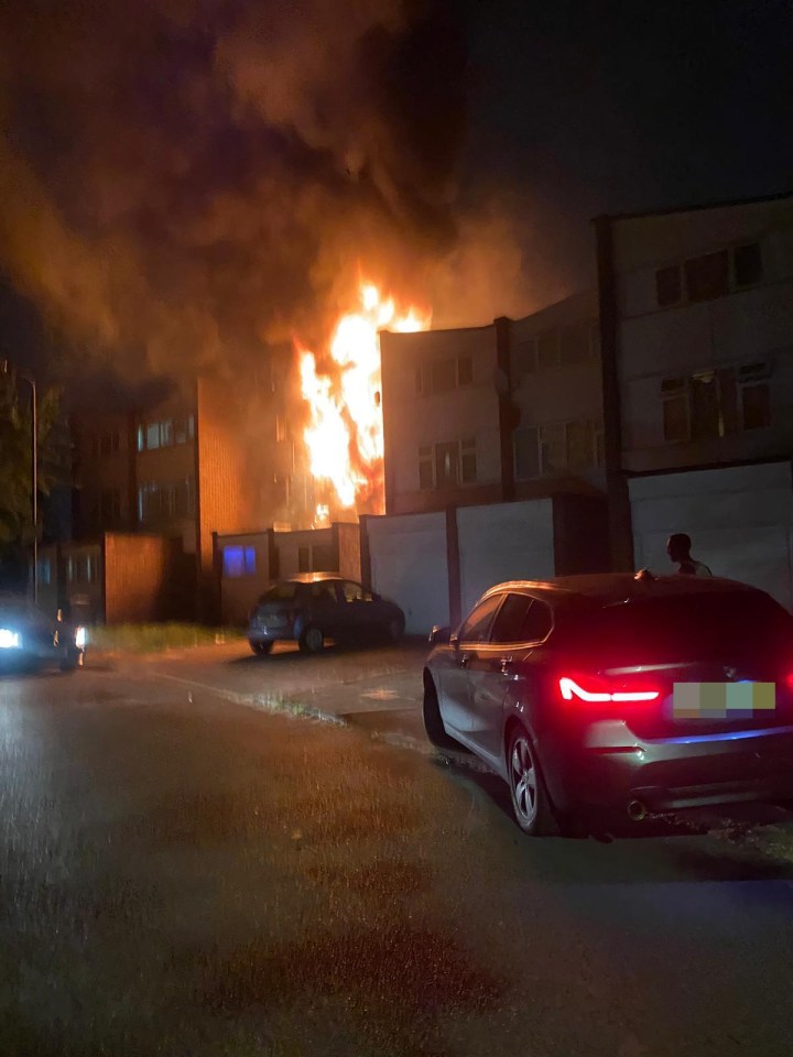 A building engulfed in flames at night.