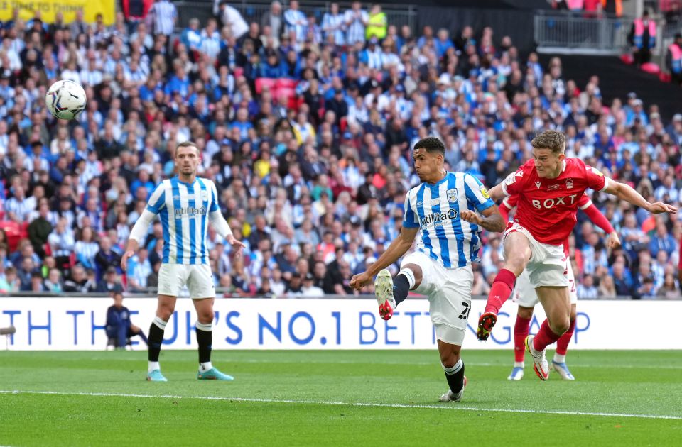 A soccer player scoring a goal during a match.