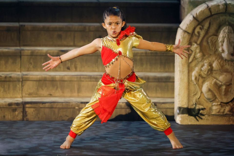 Girl in gold and red costume performing on stage.