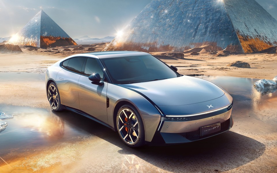 Illustration of a silver Xpeng P7 sports sedan in a desert landscape with futuristic pyramids.