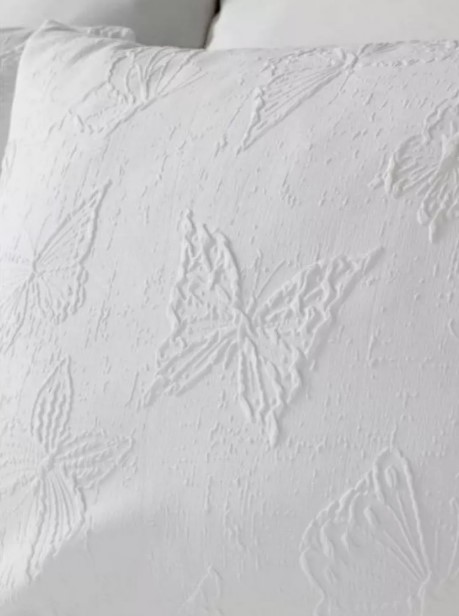 White pillowcase with embossed butterfly pattern.