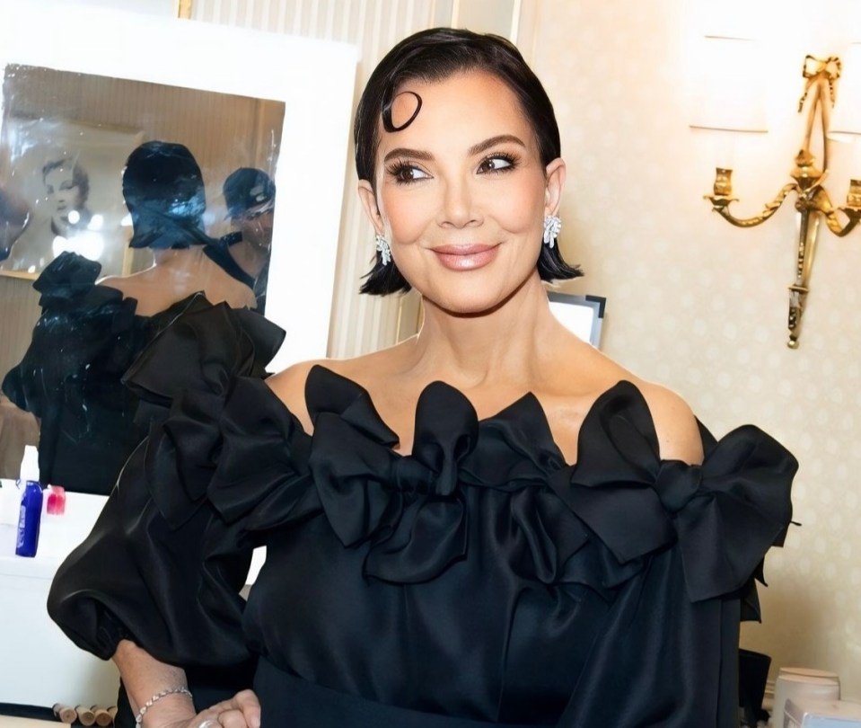 Kris Jenner in a black off-the-shoulder top and pants.