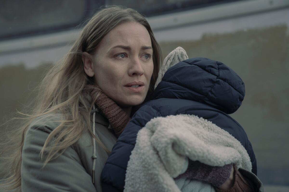 A blonde woman holds a baby