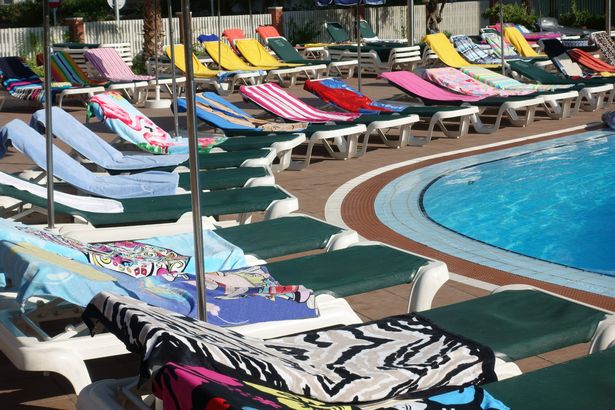 Sunbeds with towels around a pool