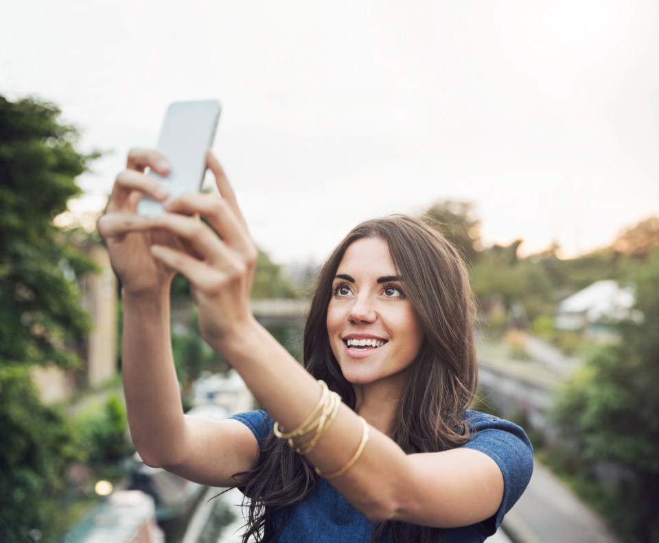 Woman taking a selfie outdoors.