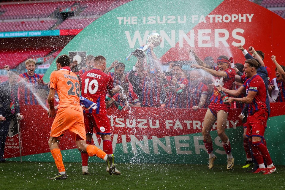 Aldershot Town soccer team celebrating victory with champagne.