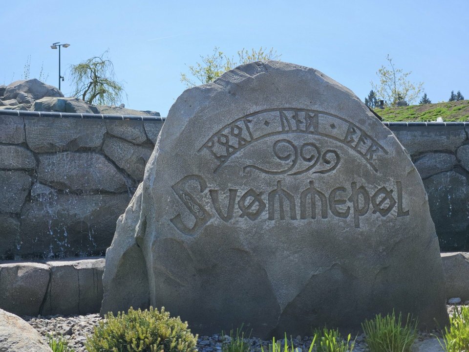 Stone carving with the word "Svinnepel" and runes.