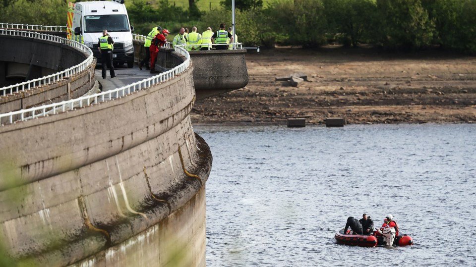 Police and emergency personnel searching a reservoir.