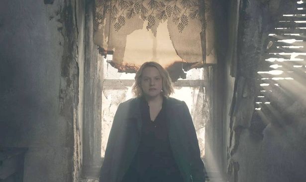 A woman sits in front of a window