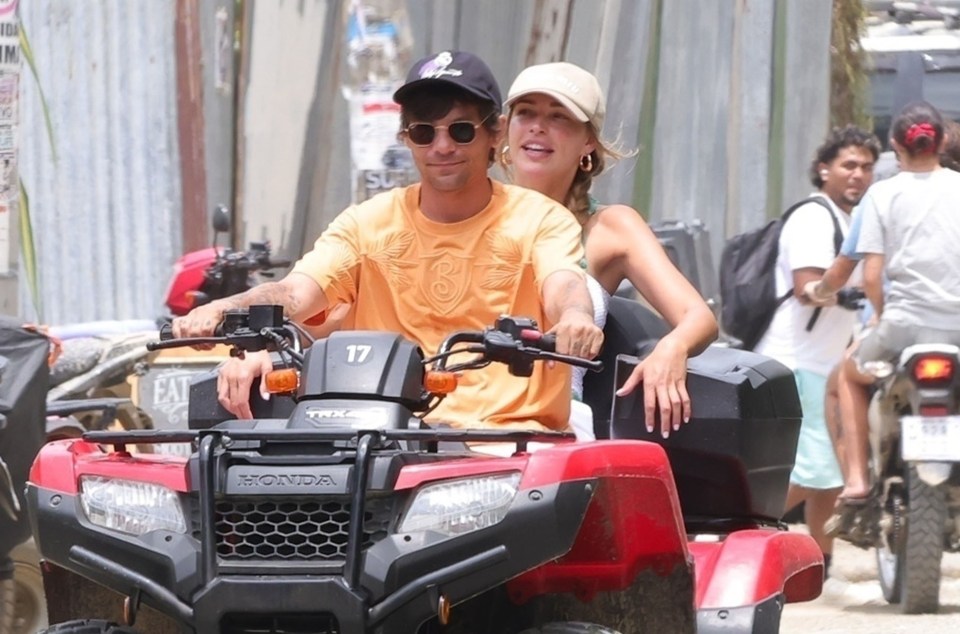 Louis Tomlinson and Zara McDermott riding an ATV.