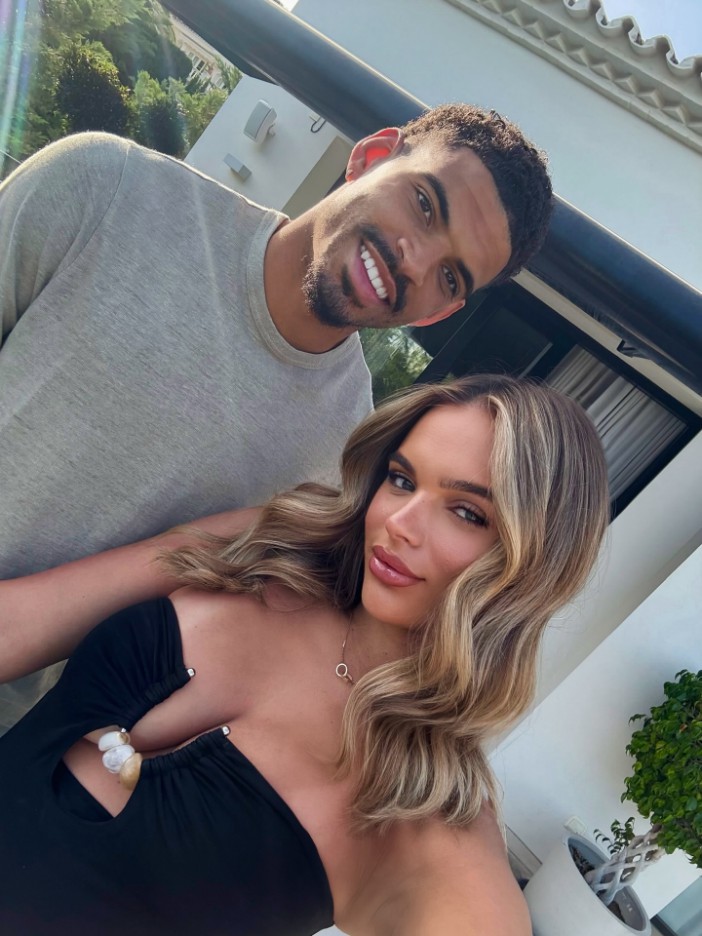 Couple posing for a selfie in front of a house.