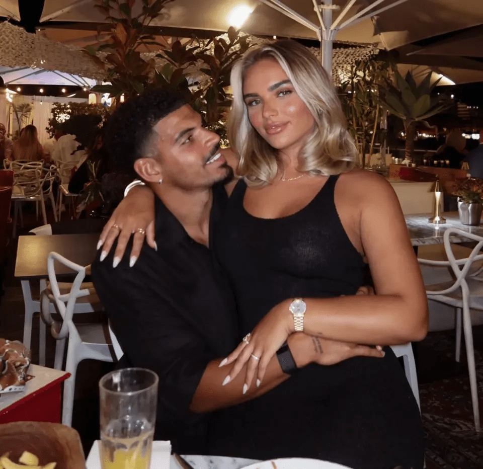 Couple embracing at an outdoor restaurant.