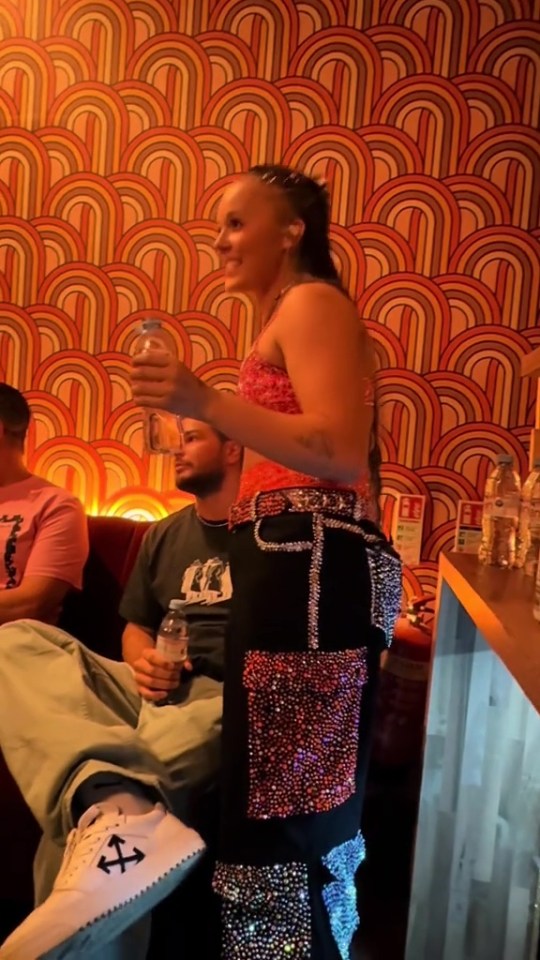 JoJo Siwa and Chris Hughes backstage; Siwa holds a water bottle.