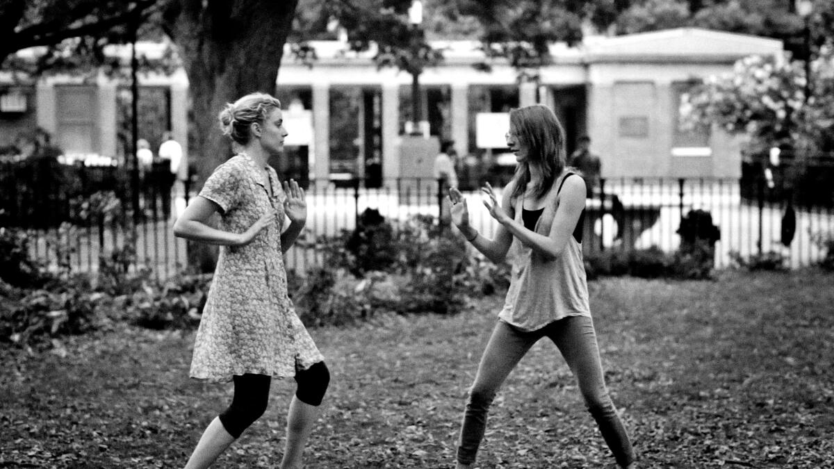 Two women dance on a lawn.