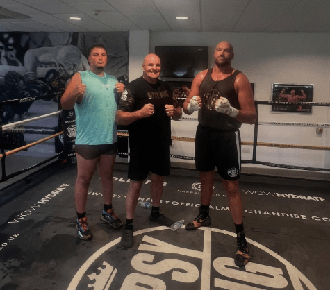 Three boxers in a boxing ring.