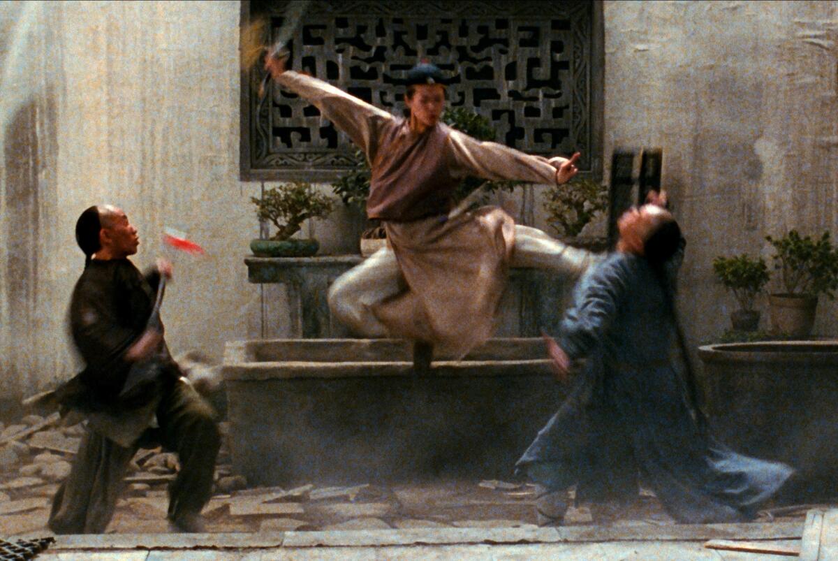 A woman kicks two people at once.