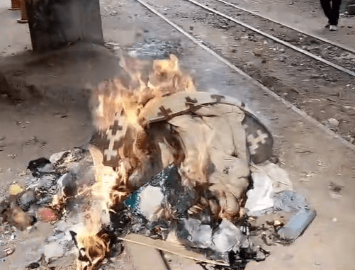 Burning trash and debris near train tracks.
