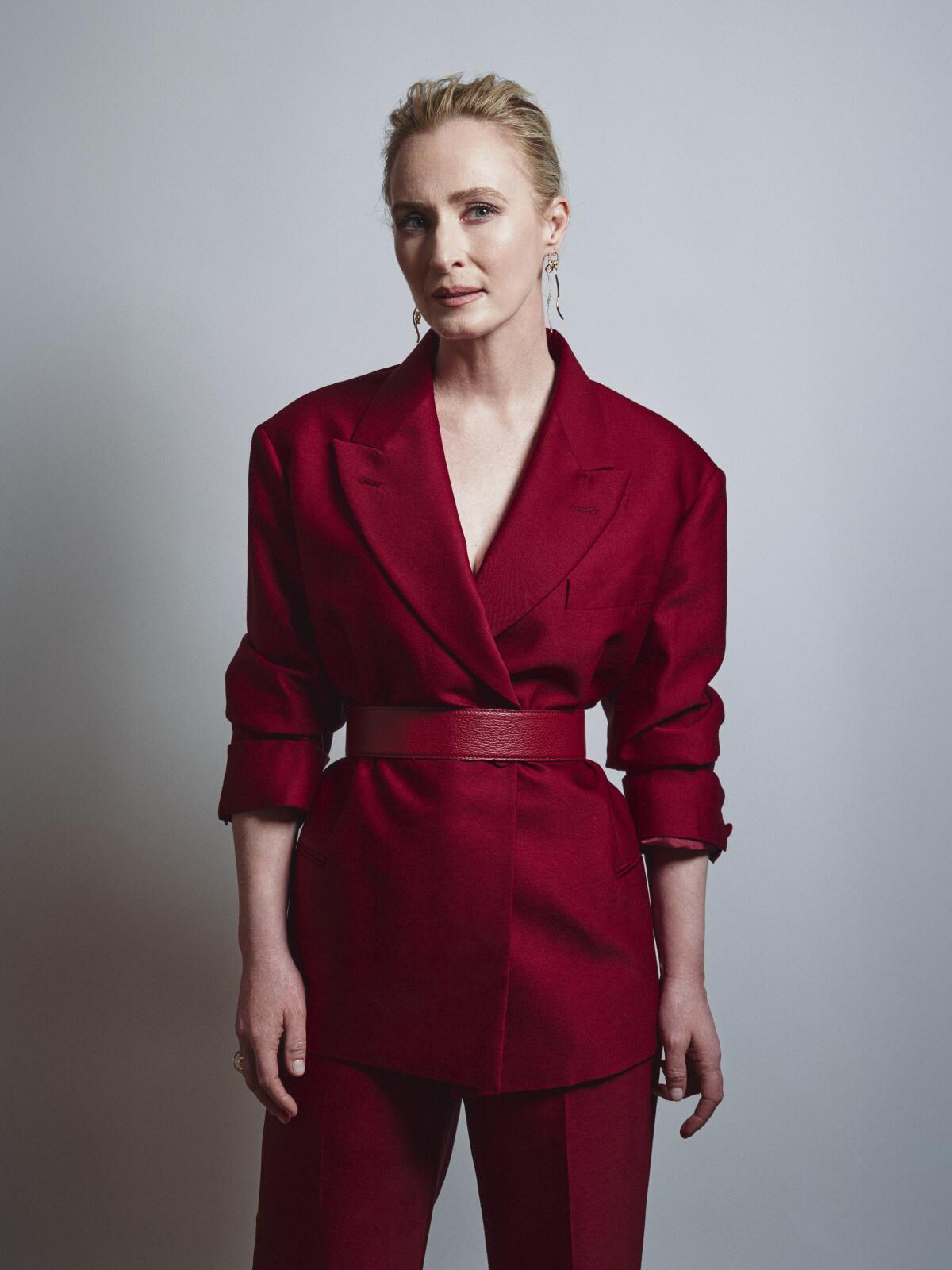 a portrait of actor Genevieve O’Reilly in a red suit