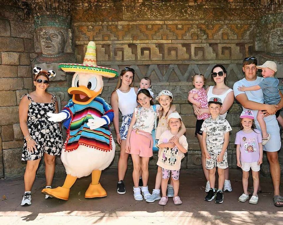 Family posing with Donald Duck in a Mexican costume.