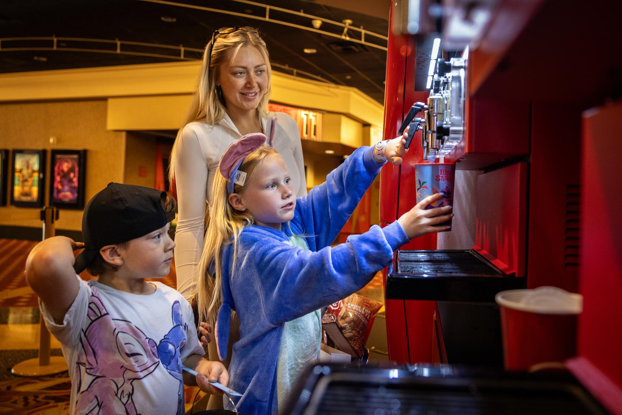 Aria Clark fills up her Lilo and Stitch cup with slushy before going into the movie with her mom and brother.