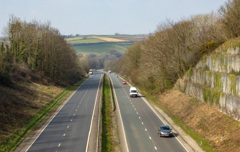 A38 highway in Liskeard, Cornwall, with cars driving on a sunny day.