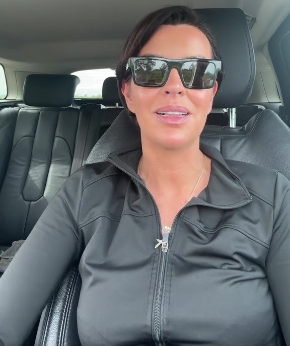 Woman in sunglasses speaking in a car.