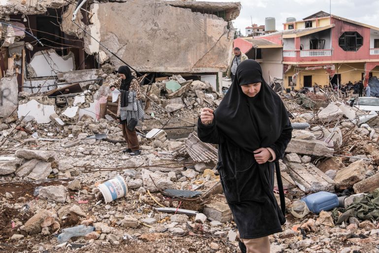 Ali Shaabi's relatives stand outside their homes destroyed during the ceasefire in Naqoura, south Lebanon