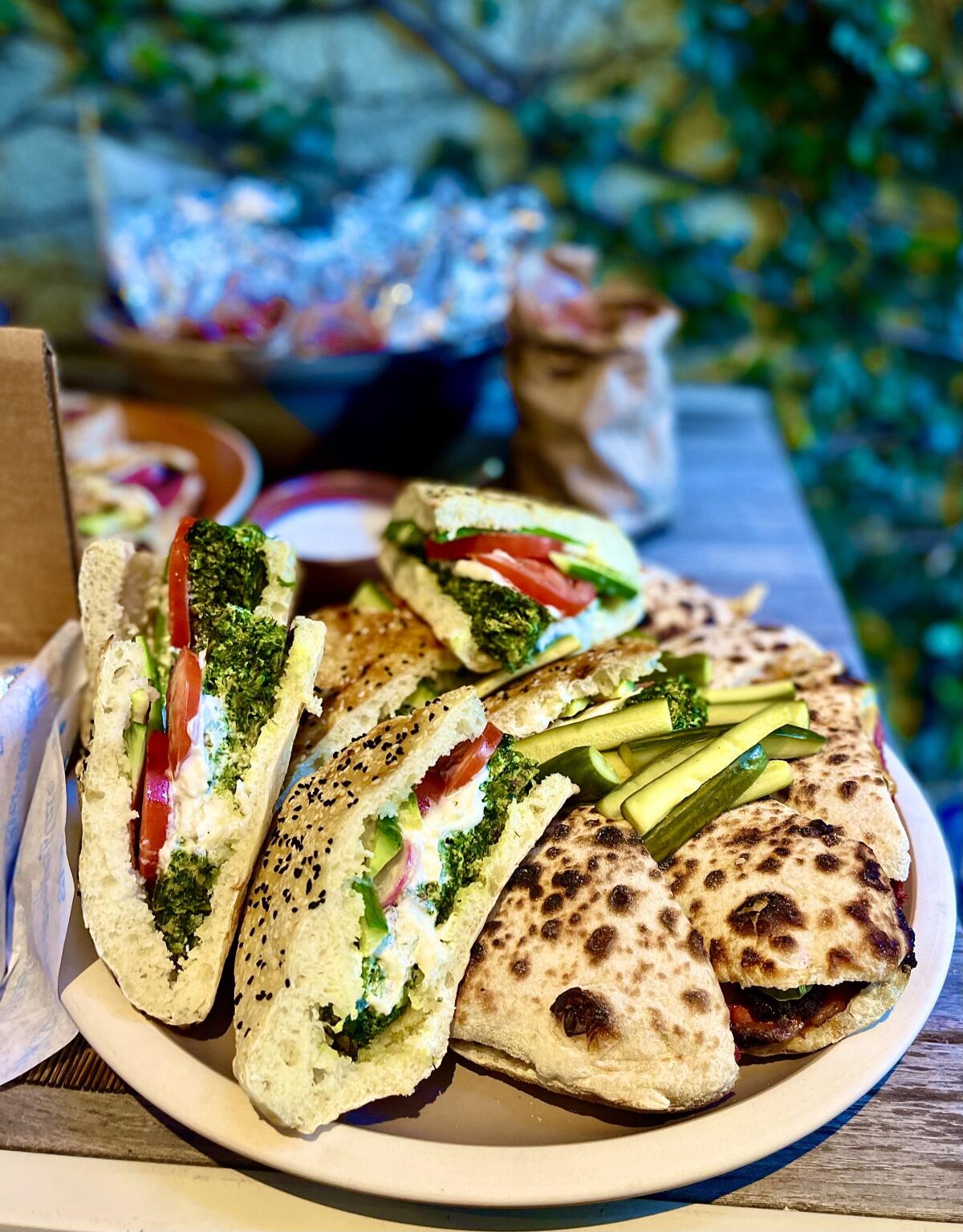 Azizam's kuku sandevich, flatbread with herb-and-leek frittata, yogurt, cucumber, tomato and radish.