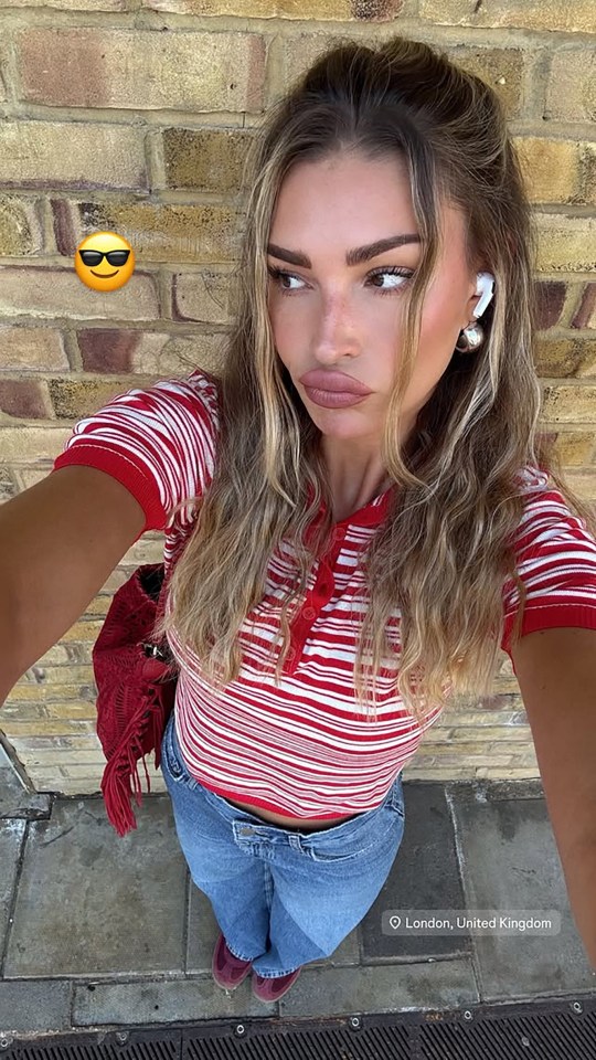 Selfie of a woman in London wearing a red and white striped shirt and blue jeans.