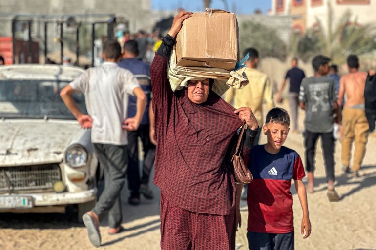 TOPSHOT - Displaced Palestinians receive food packages from a US-backed foundation pledging to distribute humanitarian aid in western Rafah in the southern Gaza Strip on May 27, 2025.