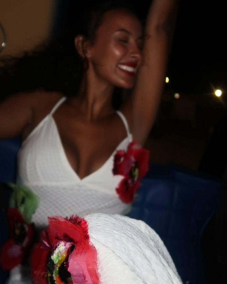 Maya Jama in a white maxi dress with floral embellishments.