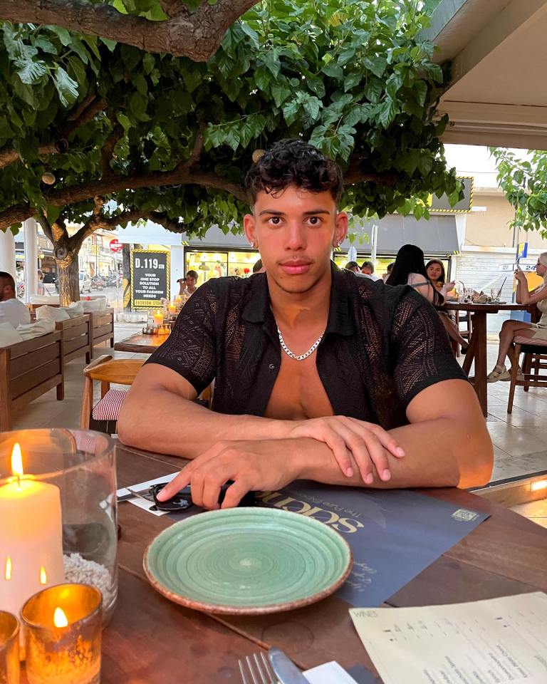 Man sitting at an outdoor restaurant table.