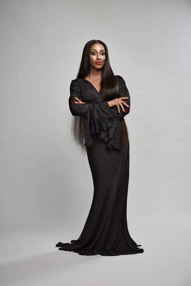Alexandra Burke as Morticia in a black gown.