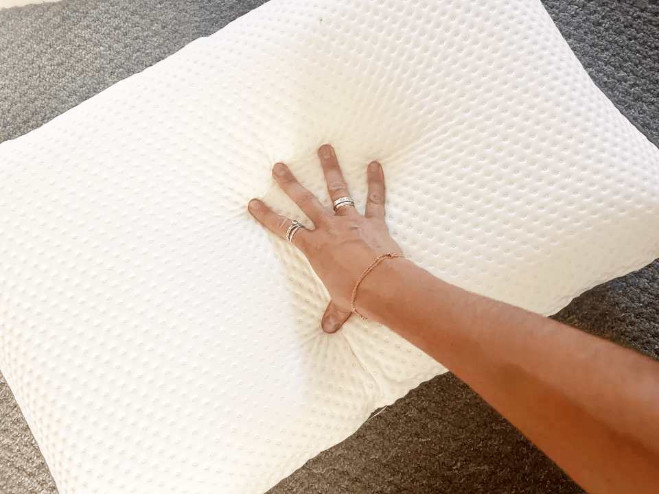 Hand pressing a white pillow.