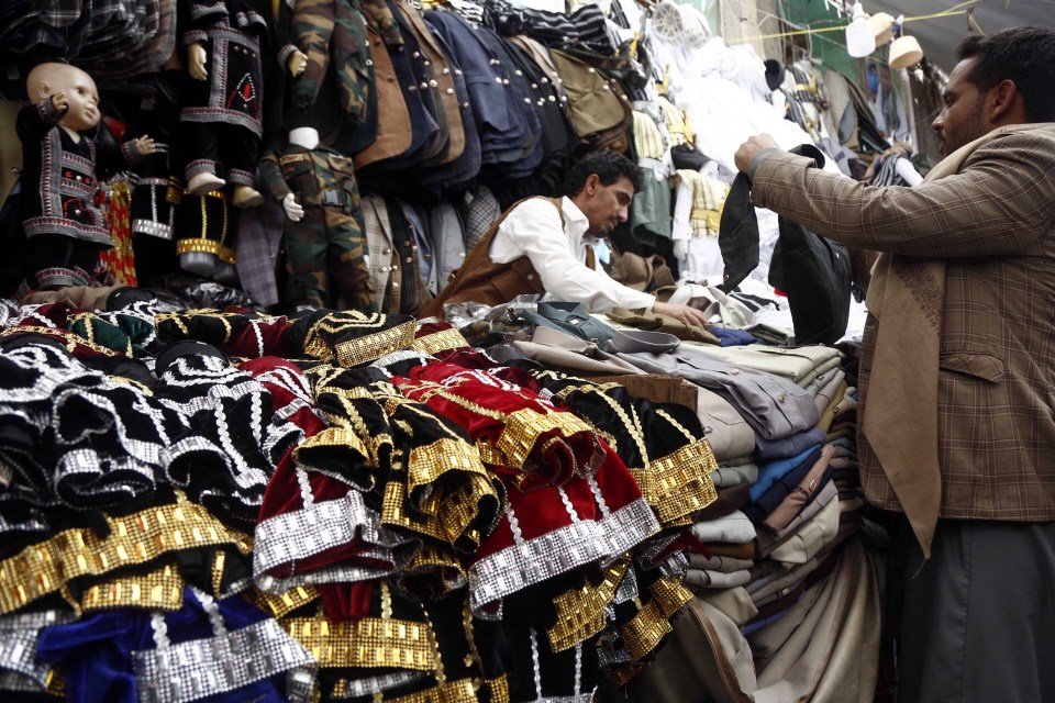 Shoppers browse clothing at a market.