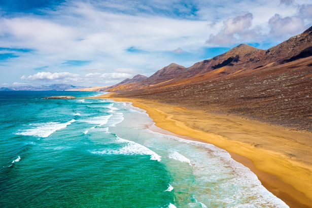 Ocean waves crashing on golden sand of Cofete Beach, Jandia Nature Park, Fuerteventura, Canary Islands, Spain