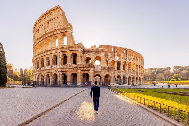 A view of a tourist walking towards Rome's Colosseum