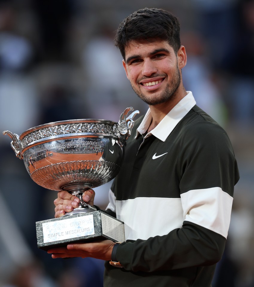 Carlos Alcaraz holding the Coupe des Mousquetaires trophy.
