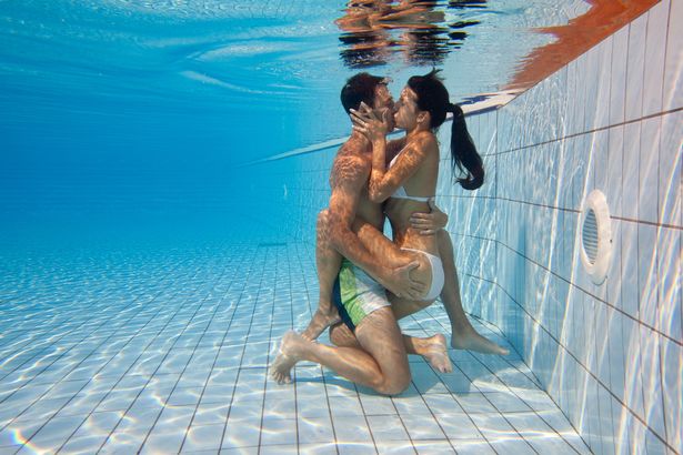 A picture of a couple kissing under water