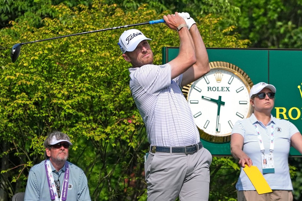 Golfer teeing off at a golf tournament.