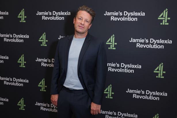 Jamie Oliver in a blue top and suit at an event in June 2025.