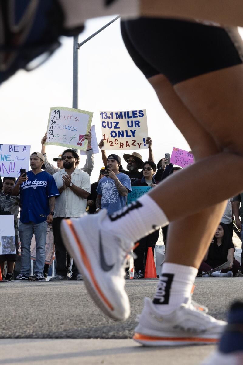 Supporters cheer and hold signs as runners embark on the Nike After Dark half marathon.